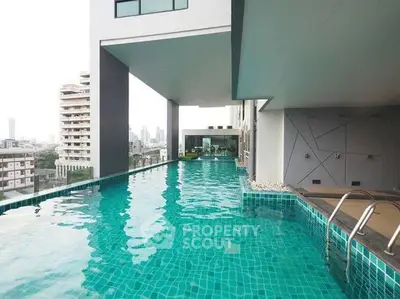 Luxurious rooftop pool with stunning city views in modern high-rise building.