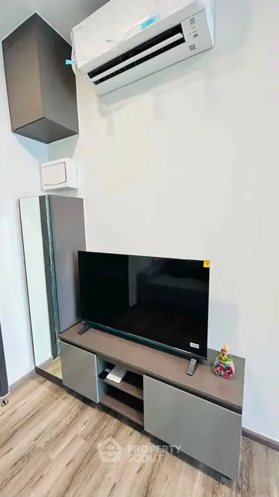 Modern living room with sleek TV unit and air conditioning, perfect for cozy entertainment.