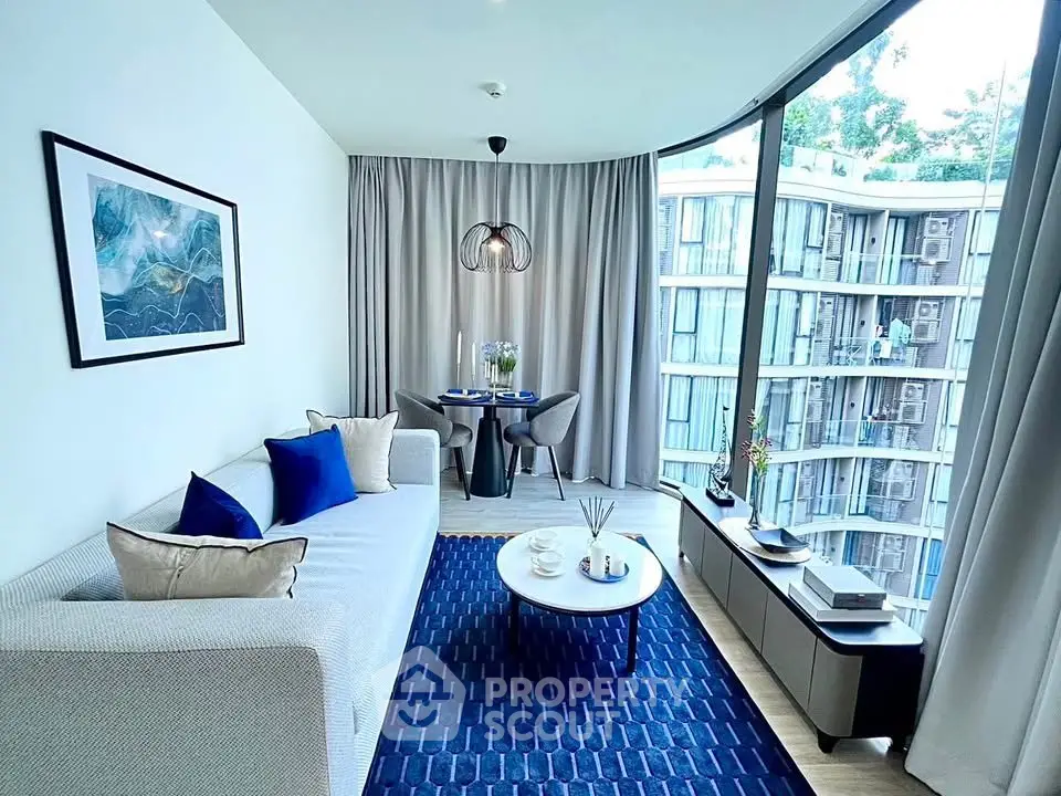 Modern living room with large windows and stylish decor in a high-rise apartment.