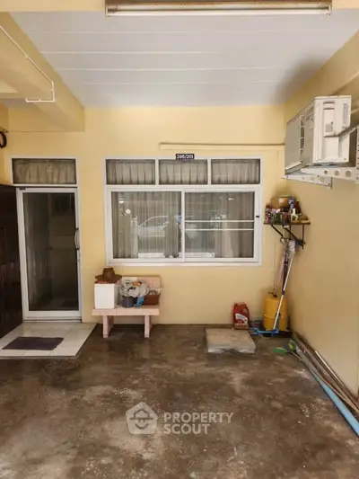 Charming home entrance with window and air conditioning unit, perfect for cozy living.