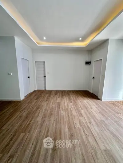 Spacious modern living room with elegant wood flooring and recessed lighting