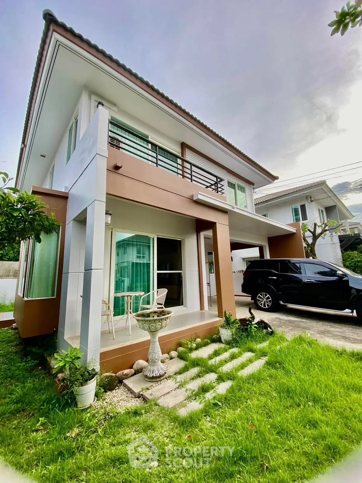 Modern two-story house with lush green lawn and sleek exterior design