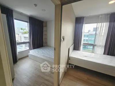 Modern dual bedroom apartment with large windows and city views, featuring sleek wooden flooring and contemporary design.