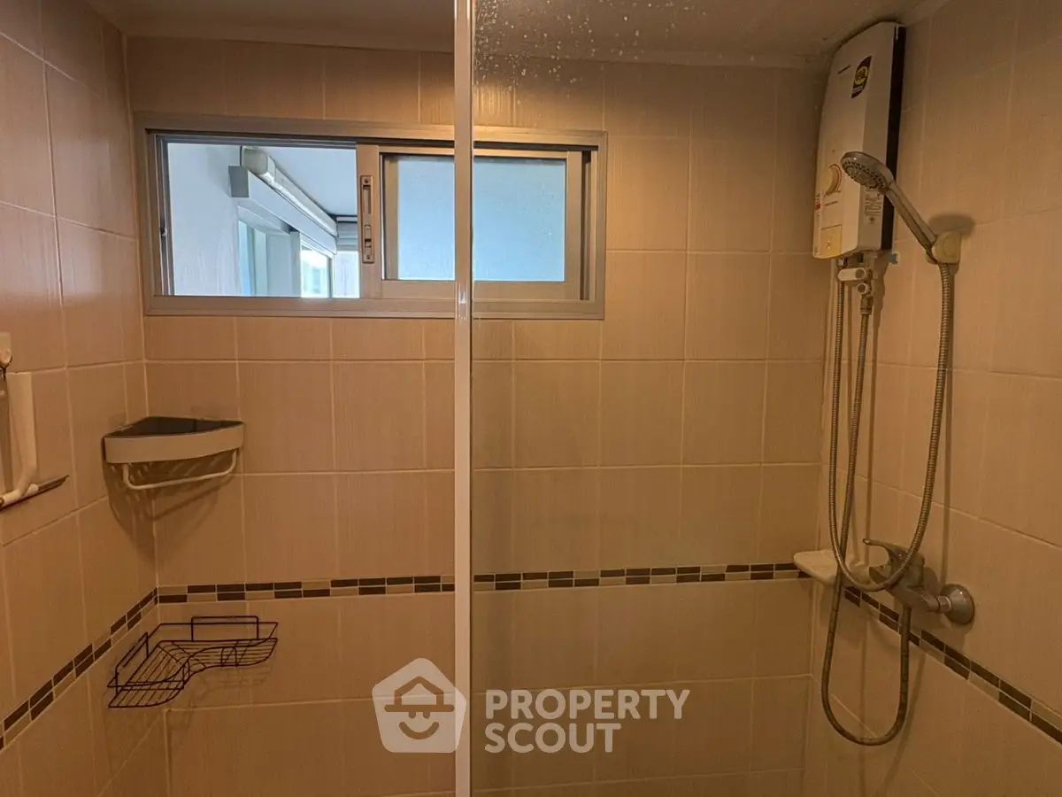 Modern bathroom with shower and water heater in a stylish real estate property.