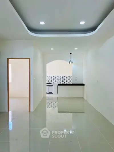 Modern open-plan kitchen with sleek design and stylish lighting in a bright, spacious interior.