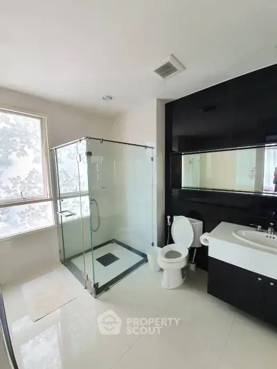 Modern bathroom with glass shower and sleek black and white design
