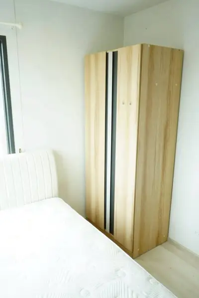 Bright bedroom with modern wardrobe and comfortable bed in minimalist style.