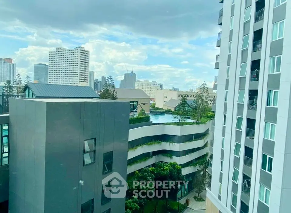 Stunning urban view from high-rise building with modern architecture and lush greenery.