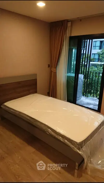 Cozy bedroom with single bed and balcony view in modern apartment