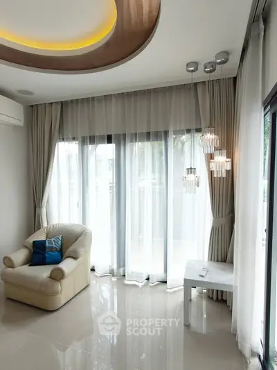 Elegant living room with modern lighting and large windows, featuring a cozy armchair and sleek tile flooring.