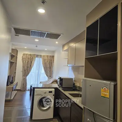 Modern kitchen with washing machine and open layout in stylish apartment