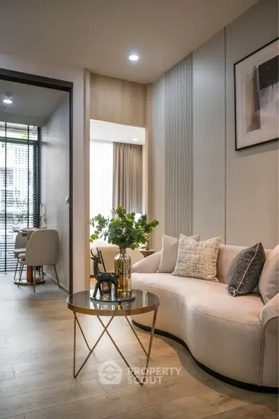 Modern living room with elegant decor and stylish furniture, featuring a cozy curved sofa and chic coffee table.