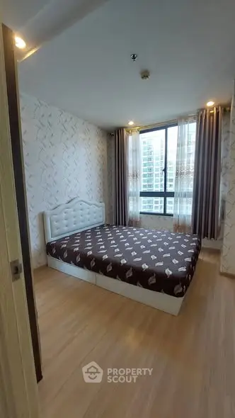 Cozy bedroom with large window and modern decor in high-rise apartment