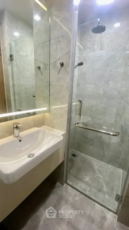 Modern bathroom with sleek glass shower and elegant marble tiles