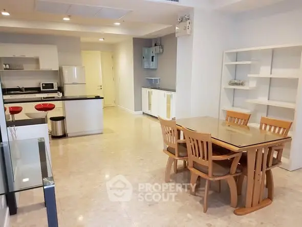 Spacious open-plan kitchen and dining area with modern furnishings and ample natural light.