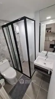 Modern bathroom with glass shower and sleek fixtures in contemporary apartment.