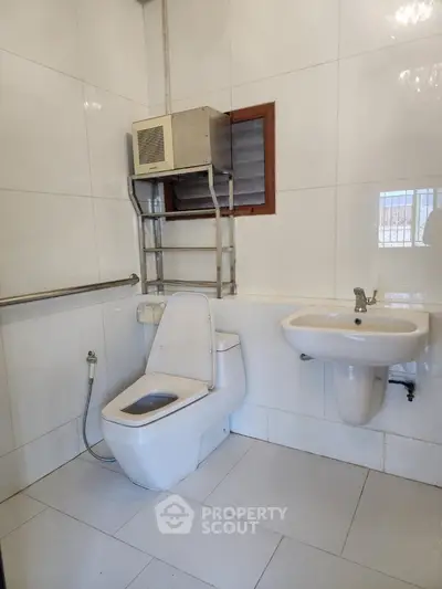 Spacious modern bathroom with sleek white fixtures and ample storage space.