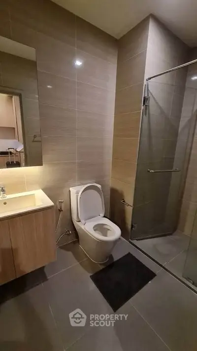 Modern bathroom with sleek design featuring glass shower and contemporary fixtures.