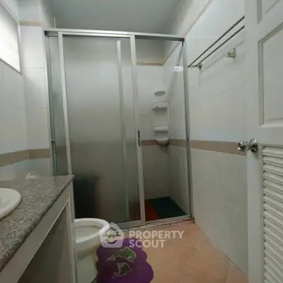 Compact bathroom with shower and modern fixtures in a cozy home setting.