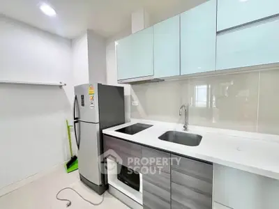 Modern kitchen with sleek cabinetry and stainless steel appliances in a contemporary apartment.