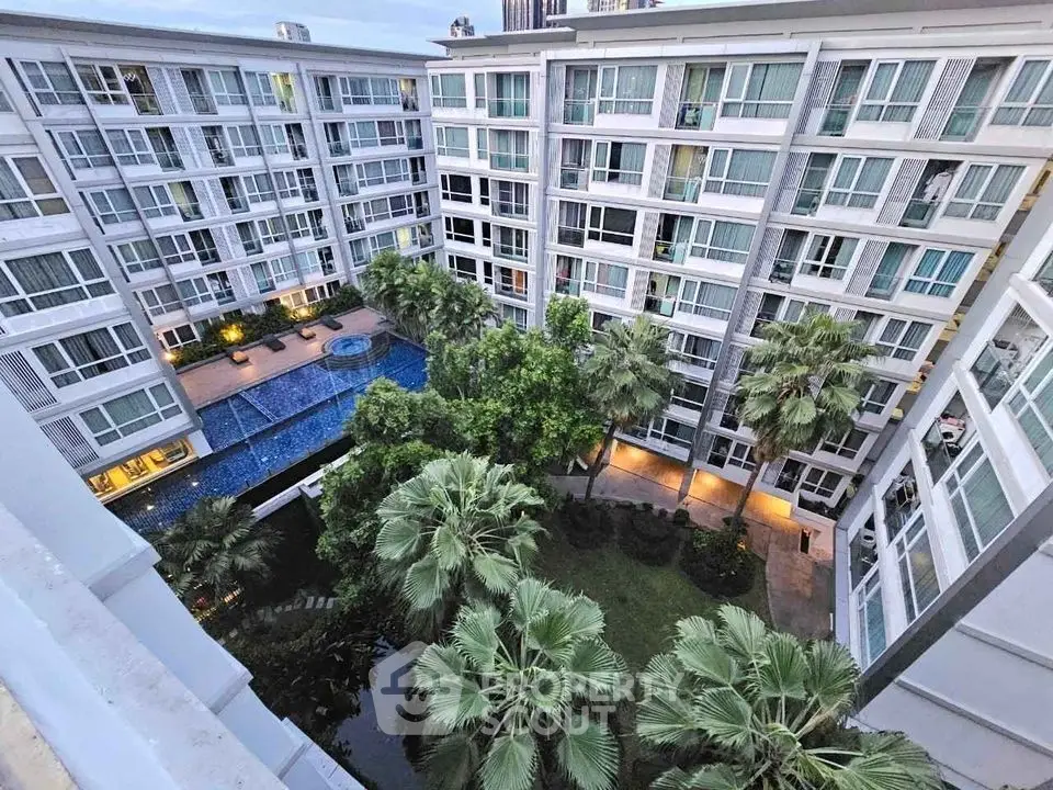 Modern apartment complex with lush garden and pool view