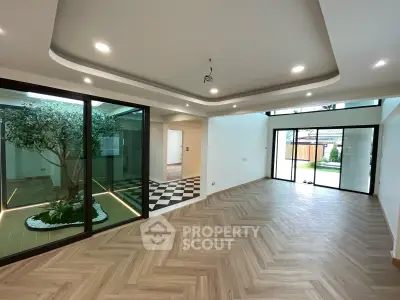 Spacious modern living room with large windows and elegant flooring