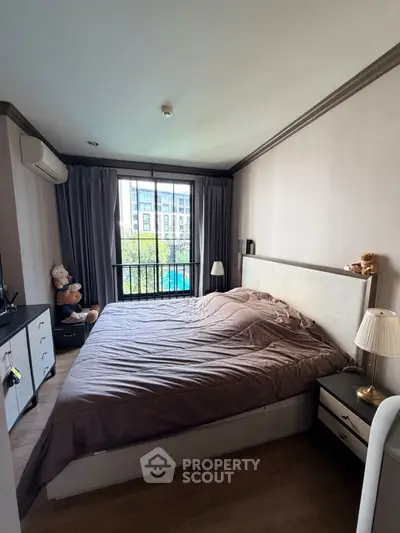 Cozy bedroom with large window and modern decor in urban apartment