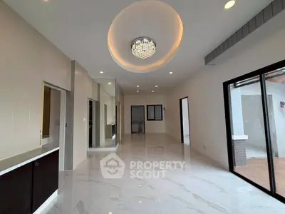 Spacious modern living room with elegant chandelier and marble flooring