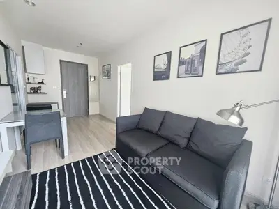 Modern living room with sleek gray sofa and stylish decor in a contemporary apartment.