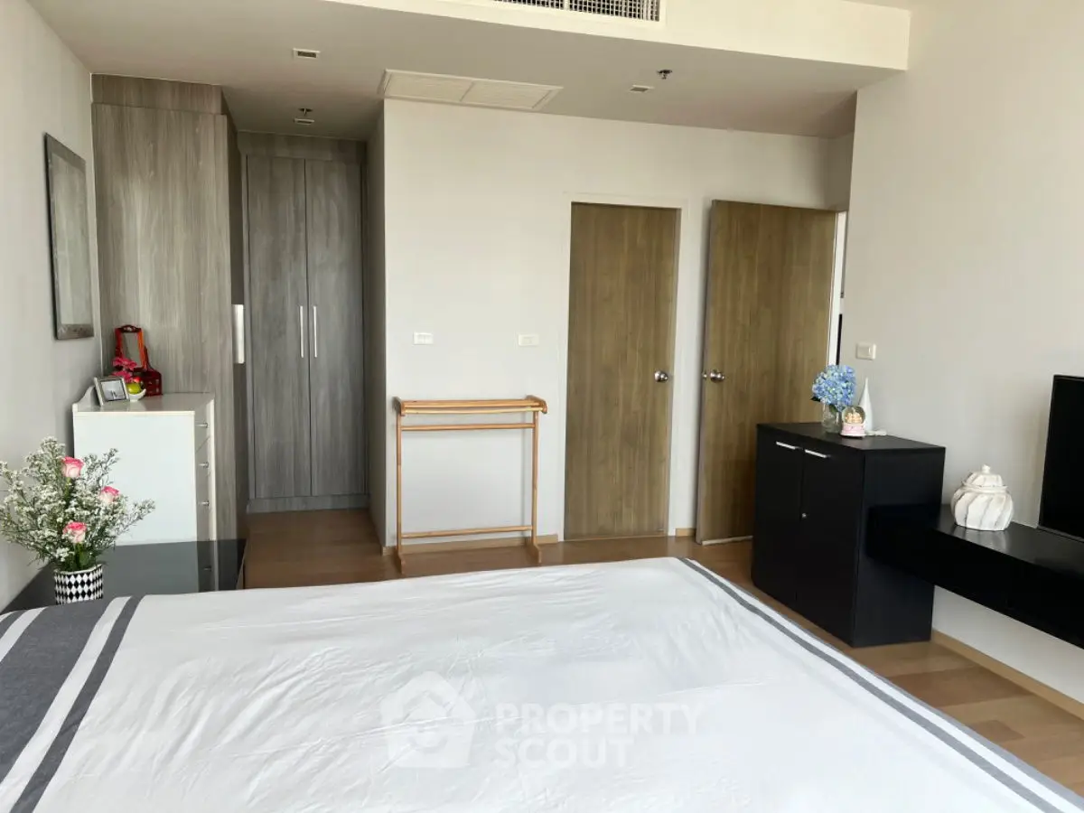 Spacious modern bedroom with sleek wooden furniture and ample natural light.