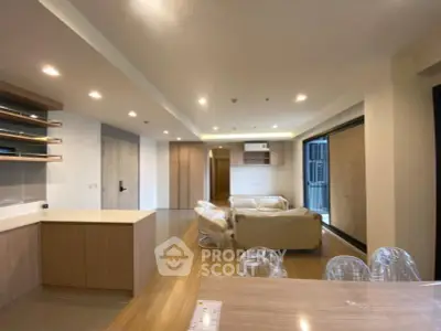 Spacious modern living room with open kitchen and elegant wooden flooring.