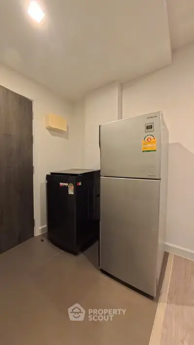 Modern kitchen corner with sleek refrigerator and compact appliances