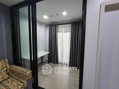 Modern apartment with glass partition and stylish curtains, perfect for urban living.