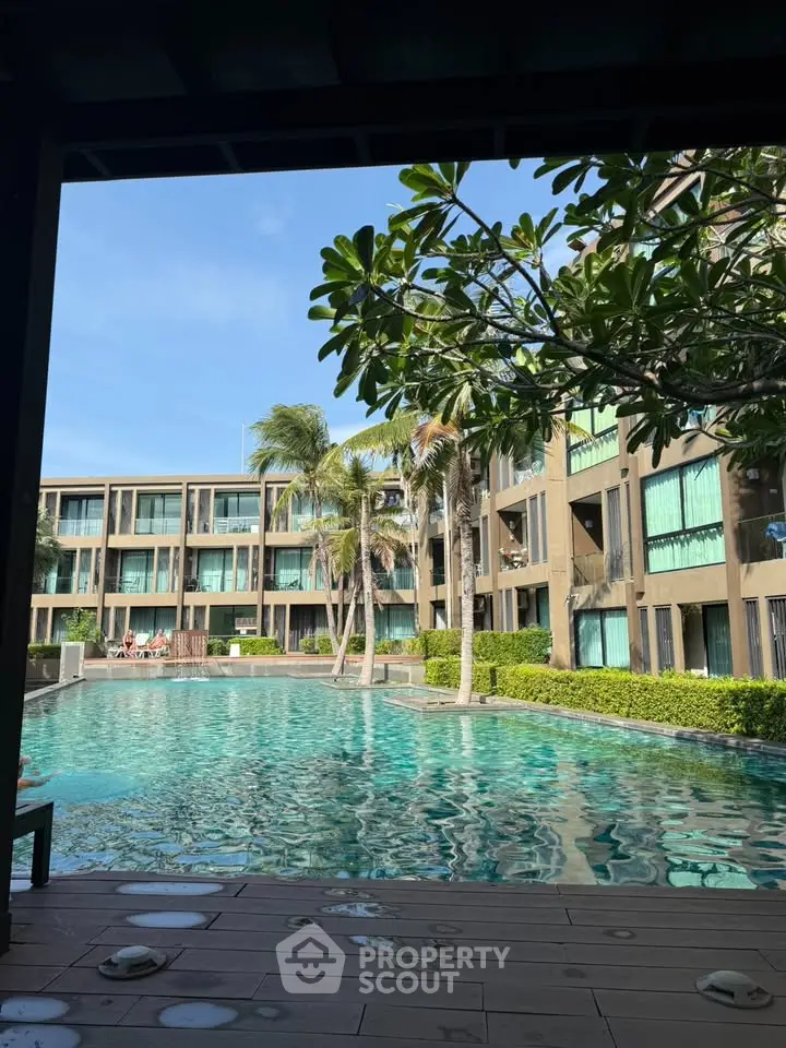 Luxurious resort-style pool with palm trees and modern apartment building view.