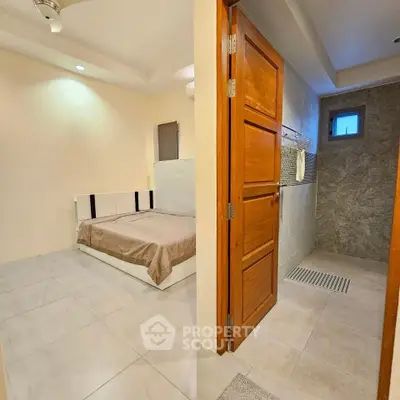 Modern bedroom with ensuite bathroom featuring sleek design and neutral tones.