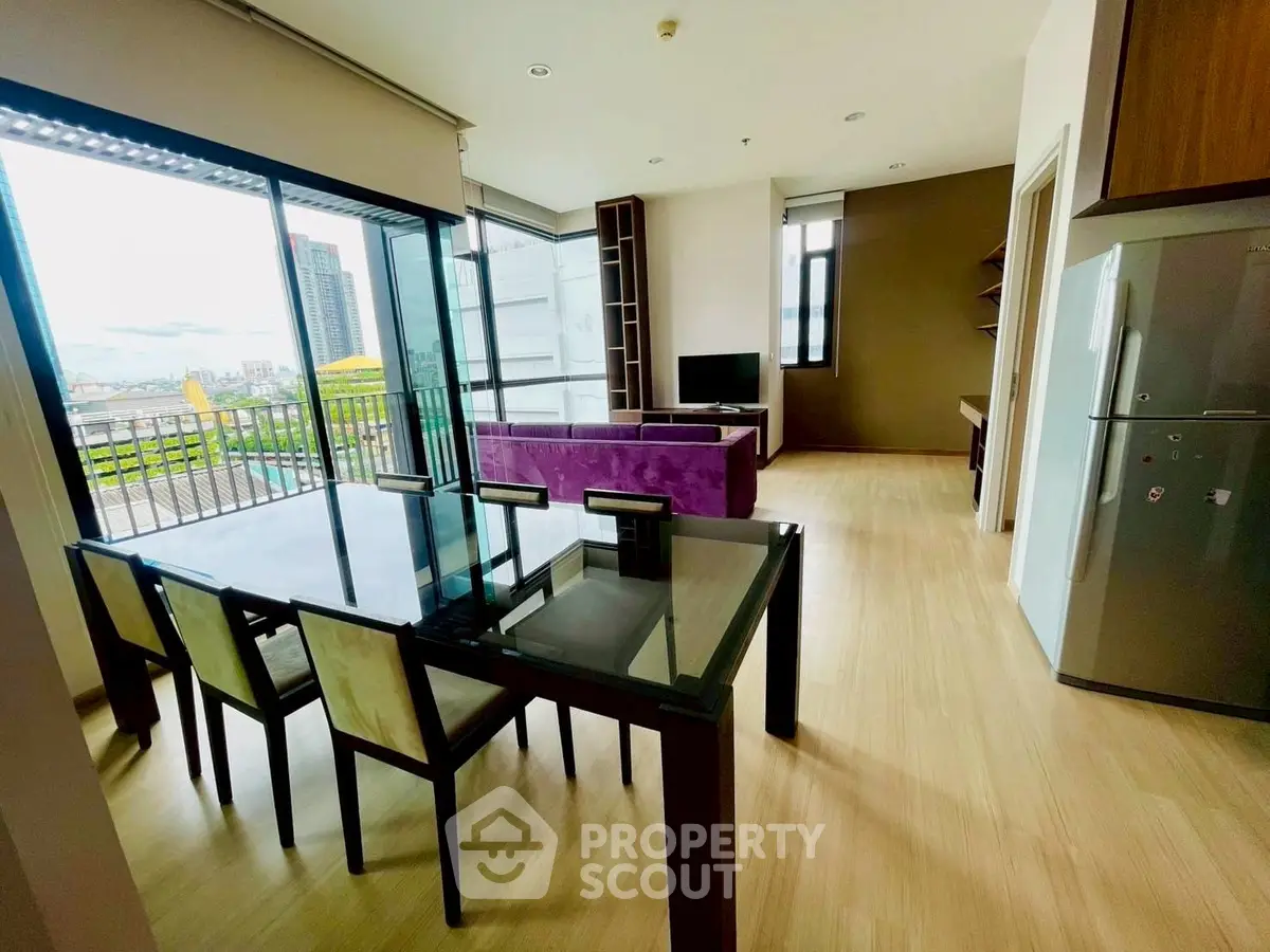 Modern open-plan living room with balcony view and sleek furniture