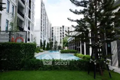 Modern apartment complex with lush garden and inviting swimming pool