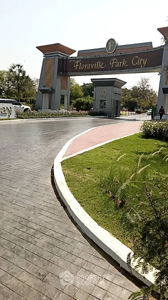 Elegant entrance of Floraville Park City with lush greenery and modern design, inviting residents into a serene and upscale community.