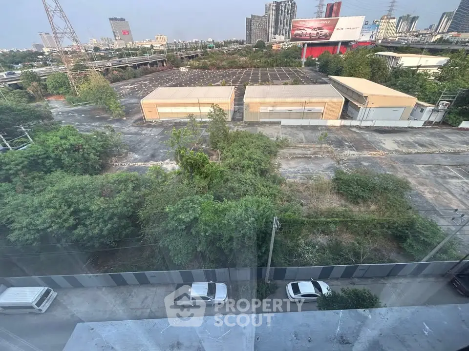 Stunning urban view from high-rise apartment overlooking cityscape and greenery, ideal for modern living.