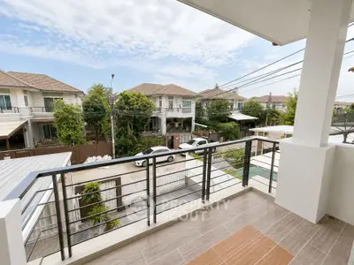 Charming balcony view of suburban neighborhood with modern houses and lush greenery.