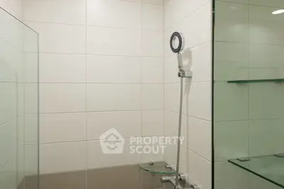 Modern bathroom with sleek shower design and glass shelves