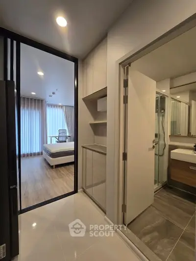 Modern apartment interior with bedroom and bathroom, featuring sleek design and natural lighting.