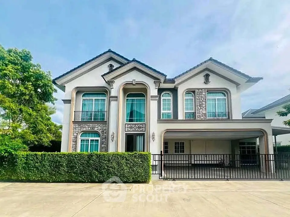 Elegant two-story house with classic facade and lush greenery