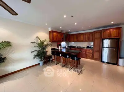 Spacious kitchen with wooden cabinets and modern appliances in open layout