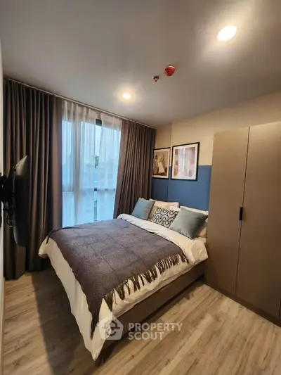 Modern bedroom with cozy decor and large window for natural light