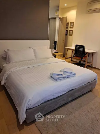 Cozy bedroom with modern decor and workspace, perfect for relaxation and productivity.