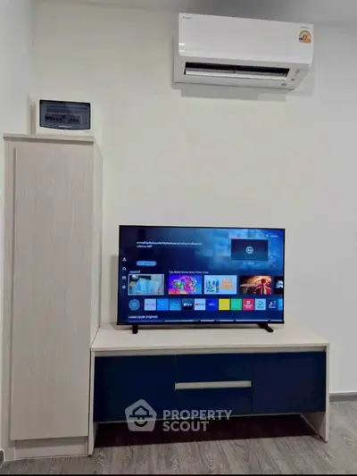 Modern living room with sleek TV setup and air conditioning unit, perfect for comfortable living.