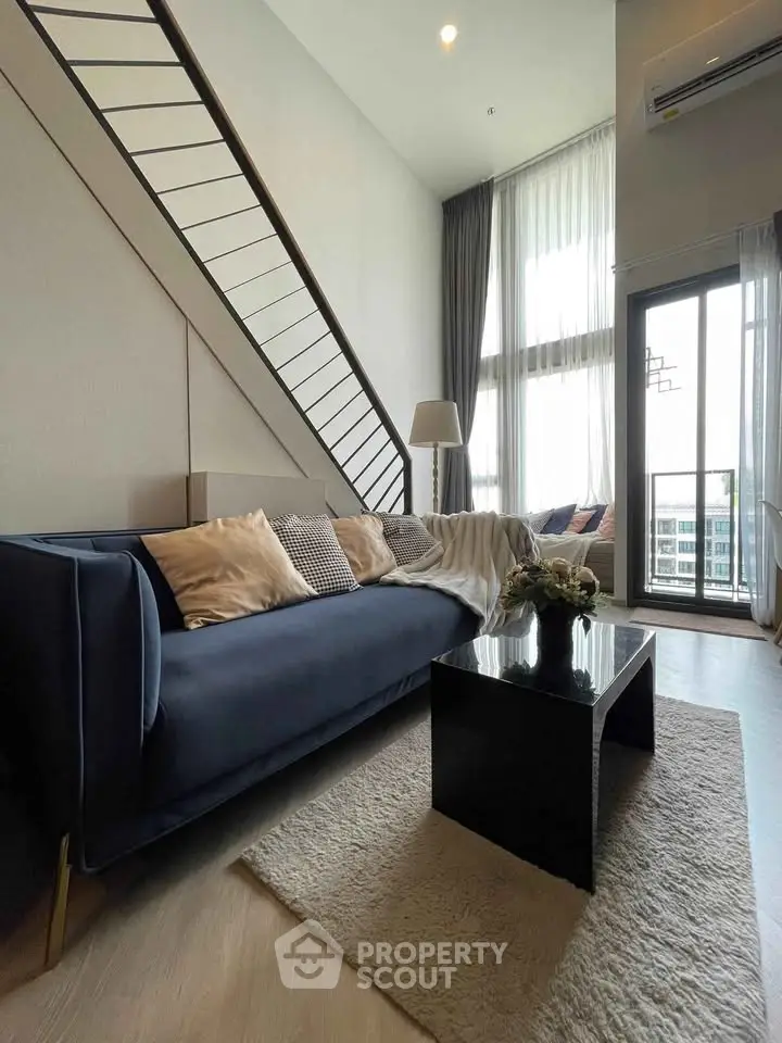 Modern living room with high ceiling and stylish decor in a luxury apartment.