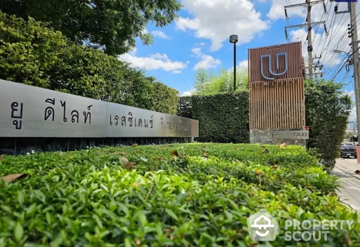 Modern building entrance with lush greenery and stylish signage