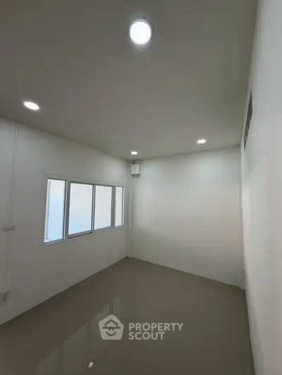 Minimalist room with glossy floor and recessed lighting, perfect for versatile use.